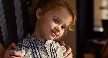 Movie still from “We Bought a Zoo” (2011), directed by Cameron Crowe – A little girl is smiling for the camera; Close Up shot, Over the shoulder angle