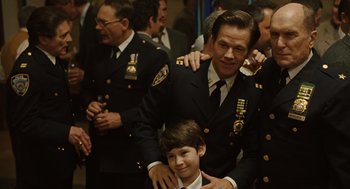 Movie still from “We Own the Night” (2007), directed by James Gray – A group of men standing next to each other in a room; Medium shot, Over the shoulder angle