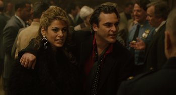 Movie still from “We Own the Night” (2007), directed by James Gray – A man and a woman standing next to each other in a crowd; Close Up shot, Over the shoulder angle