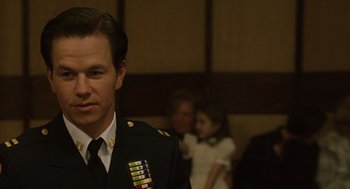 Movie still from “We Own the Night” (2007), directed by James Gray – A man in uniform standing in front of a group of people; Close Up shot, Over the shoulder angle