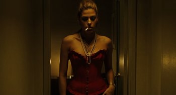Movie still from “We Own the Night” (2007), directed by James Gray – A woman smoking a cigarette while wearing a red corset; Medium shot, Low angle