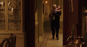 Movie still from “We Own the Night” (2007), directed by James Gray – A man and a woman are kissing in a hallway; Wide shot, Over the shoulder angle