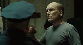 Movie still from “We Own the Night” (2007), directed by James Gray – An older man is looking in the bathroom mirror; Close Up shot, Over the shoulder angle