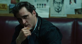 Movie still from “We Own the Night” (2007), directed by James Gray – A person holding a pen in his mouth; Close Up shot, Over the shoulder angle