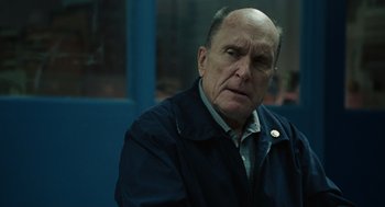 Movie still from “We Own the Night” (2007), directed by James Gray – An older man in a black jacket is looking at the camera; Close Up shot, Over the shoulder angle