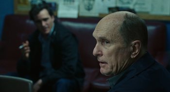 Movie still from “We Own the Night” (2007), directed by James Gray – A man sitting next to another man on a couch; Close Up shot, Over the shoulder angle