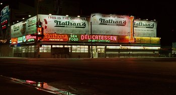 Movie still from “We Own the Night” (2007), directed by James Gray – Nathan's restaurant at night with neon signs lit up; Extreme Wide shot, Low angle