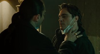 Movie still from “We Own the Night” (2007), directed by James Gray – A man putting on a tie while another man looks on; Close Up shot, Over the shoulder angle
