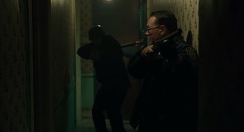 Movie still from “We Own the Night” (2007), directed by James Gray – Two men in a dark hallway with guns pointed at them; Medium shot, High angle