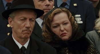Movie still from “We Own the Night” (2007), directed by James Gray – An older man and a younger woman in a crowd of people; Close Up shot, Low angle