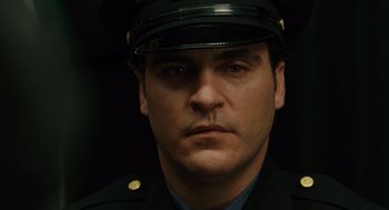 Movie still from “We Own the Night” (2007), directed by James Gray – A man in a police officer's uniform stares into the camera; Close Up shot, Over the shoulder angle