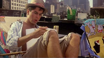 Movie still from “Weekend at Bernie's” (1989), directed by Ted Kotcheff – A man sitting on the ground writing on a piece of paper; Medium shot, Low angle