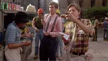 Movie still from “Weekend at Bernie's” (1989), directed by Ted Kotcheff – A group of people standing on the sidewalk eating hot dogs; Medium shot, Over the shoulder angle