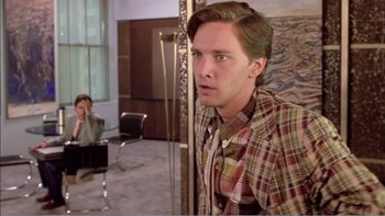 Movie still from “Weekend at Bernie's” (1989), directed by Ted Kotcheff – A man in a plaid shirt looking at the camera; Medium shot, Over the shoulder angle