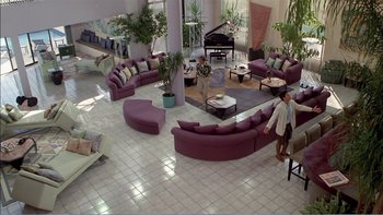 Movie still from “Weekend at Bernie's” (1989), directed by Ted Kotcheff – A living room filled with purple furniture and a piano; Extreme Wide shot, High angle