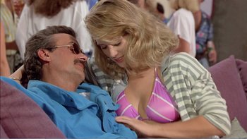Movie still from “Weekend at Bernie's” (1989), directed by Ted Kotcheff – A man and a woman in a pink striped bikini; Medium shot, Over the shoulder angle