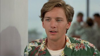 Movie still from “Weekend at Bernie's” (1989), directed by Ted Kotcheff – A young man wearing a hawaiian shirt looks into the camera; Close Up shot, Over the shoulder angle