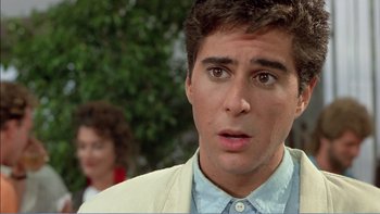 Movie still from “Weekend at Bernie's” (1989), directed by Ted Kotcheff – A person wearing a suit and tie; Close Up shot, Over the shoulder angle