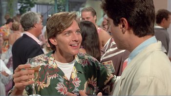Movie still from “Weekend at Bernie's” (1989), directed by Ted Kotcheff – A man wearing a hawaiian shirt talking to another man in a crowd; Medium shot, Over the shoulder angle