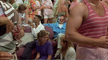 Movie still from “Weekend at Bernie's” (1989), directed by Ted Kotcheff – A group of people sitting on top of couches in a room; Wide shot, Over the shoulder angle