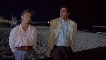 Movie still from “Weekend at Bernie's” (1989), directed by Ted Kotcheff – A man and a woman standing next to each other on the beach; Medium shot, Over the shoulder angle