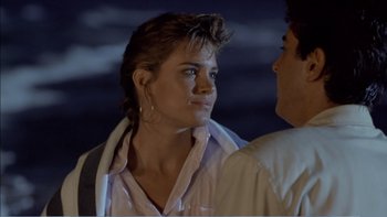 Movie still from “Weekend at Bernie's” (1989), directed by Ted Kotcheff – A man and a woman standing next to each other; Close Up shot, Over the shoulder angle