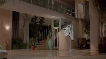 Movie still from “Weekend at Bernie's” (1989), directed by Ted Kotcheff – A room filled with lots of potted plants and a staircase; Extreme Wide shot, High angle