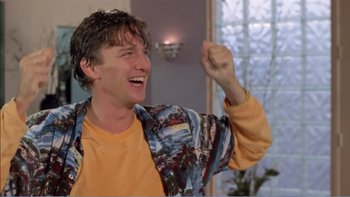 Movie still from “Weekend at Bernie's” (1989), directed by Ted Kotcheff – A young man is smiling while holding his fist up; Medium shot, Low angle