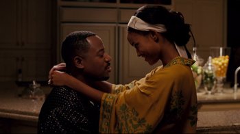 Movie still from “Welcome Home, Roscoe Jenkins” (2008), directed by Malcolm D. Lee – A man and a woman embracing each other in front of a window; Medium shot, Over the shoulder angle