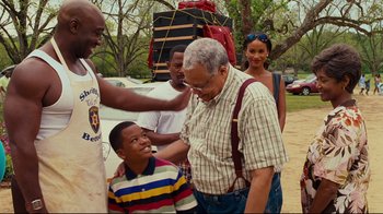 Movie still from “Welcome Home, Roscoe Jenkins” (2008), directed by Malcolm D. Lee – An older man and a young boy standing next to each other; Medium shot, Over the shoulder angle