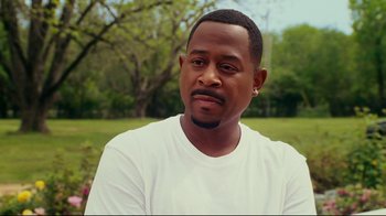 Movie still from “Welcome Home, Roscoe Jenkins” (2008), directed by Malcolm D. Lee – A person wearing a white t - shirt; Close Up shot, Over the shoulder angle