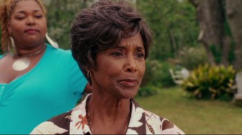 Movie still from “Welcome Home, Roscoe Jenkins” (2008), directed by Malcolm D. Lee – An older black woman wearing a brown and white floral shirt; Close Up shot, Over the shoulder angle
