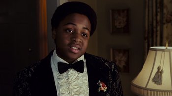 Movie still from “Welcome Home, Roscoe Jenkins” (2008), directed by Malcolm D. Lee – A young man in a suit and a bow tie; Close Up shot, Over the shoulder angle