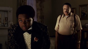 Movie still from “Welcome Home, Roscoe Jenkins” (2008), directed by Malcolm D. Lee – A man and a young boy in a suit and tie; Medium shot, Over the shoulder angle