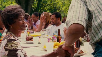 Movie still from “Welcome Home, Roscoe Jenkins” (2008), directed by Malcolm D. Lee – A group of people sitting at a table with food; Medium shot, Over the shoulder angle