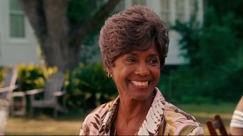 Movie still from “Welcome Home, Roscoe Jenkins” (2008), directed by Malcolm D. Lee – An older woman smiles brightly as she stands in a park; Close Up shot, Over the shoulder angle