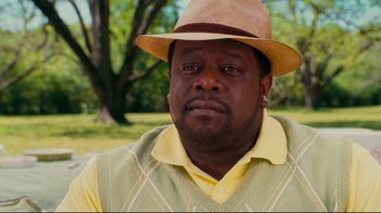 Movie still from “Welcome Home, Roscoe Jenkins” (2008), directed by Malcolm D. Lee – A person wearing a hat with trees in the background; Close Up shot, Over the shoulder angle