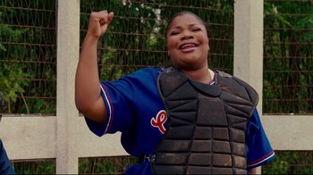 Movie still from “Welcome Home, Roscoe Jenkins” (2008), directed by Malcolm D. Lee – A female baseball player is wearing a catchers gear; Medium shot, Low angle