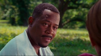 Movie still from “Welcome Home, Roscoe Jenkins” (2008), directed by Malcolm D. Lee – A person wearing a white shirt near a tree; Close Up shot, Over the shoulder angle