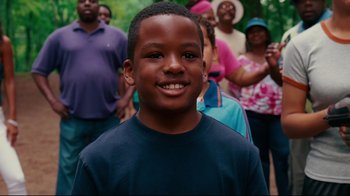 Movie still from “Welcome Home, Roscoe Jenkins” (2008), directed by Malcolm D. Lee – A young boy smiling in front of a group of people; Close Up shot, High angle