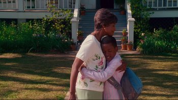 Movie still from “Welcome Home, Roscoe Jenkins” (2008), directed by Malcolm D. Lee – An older woman hugging a young boy in a yard; Medium shot, Over the shoulder angle