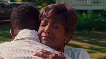 Movie still from “Welcome Home, Roscoe Jenkins” (2008), directed by Malcolm D. Lee – An older woman is hugging a younger man outside; Close Up shot, Over the shoulder angle