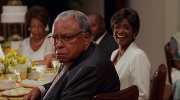 Movie still from “Welcome Home, Roscoe Jenkins” (2008), directed by Malcolm D. Lee – An older man sitting in front of a group of people; Close Up shot, Over the shoulder angle