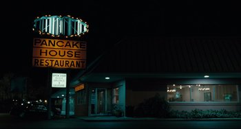Movie still from “Welcome to the Rileys” (2010), directed by Jake Scott – A lit up sign outside of a restaurant at night time; Wide shot, Low angle