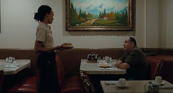 Movie still from “Welcome to the Rileys” (2010), directed by Jake Scott – A woman holding a tray of food in front of a man in a restaurant; Medium shot, Over the shoulder angle