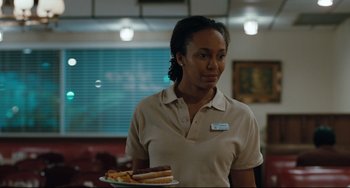 Movie still from “Welcome to the Rileys” (2010), directed by Jake Scott – A woman holding a plate of hot dogs in a restaurant; Medium shot, Over the shoulder angle