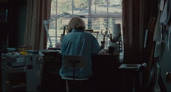 Movie still from “Welcome to the Rileys” (2010), directed by Jake Scott – A woman sitting at a desk in front of an open window; Wide shot, High angle