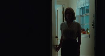 Movie still from “Welcome to the Rileys” (2010), directed by Jake Scott – A woman standing in front of a door in the dark; Medium shot, Low angle