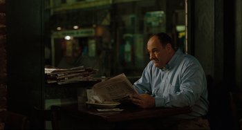 Movie still from “Welcome to the Rileys” (2010), directed by Jake Scott – A man sitting at a table reading a newspaper; Medium shot, Over the shoulder angle