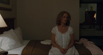 Movie still from “Welcome to the Rileys” (2010), directed by Jake Scott – A woman sitting on a bed with her hands folded on her chest; Medium shot, High angle